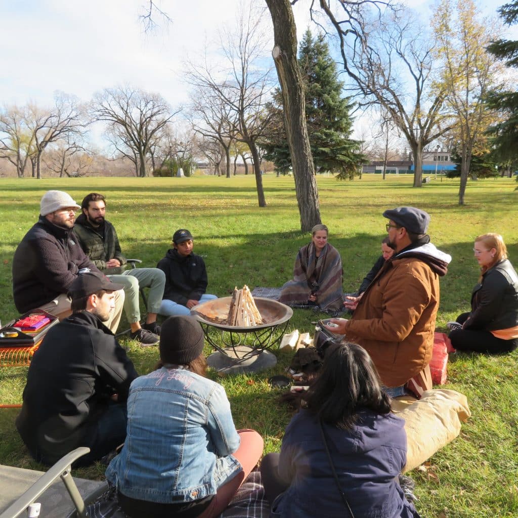 Vincent Design staff sitting around fire pit with Vern Dano