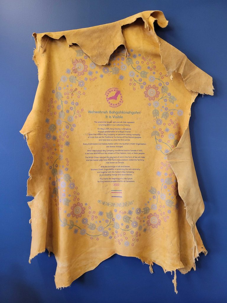 Elk hide on wall with floral motif and ceremony details on it