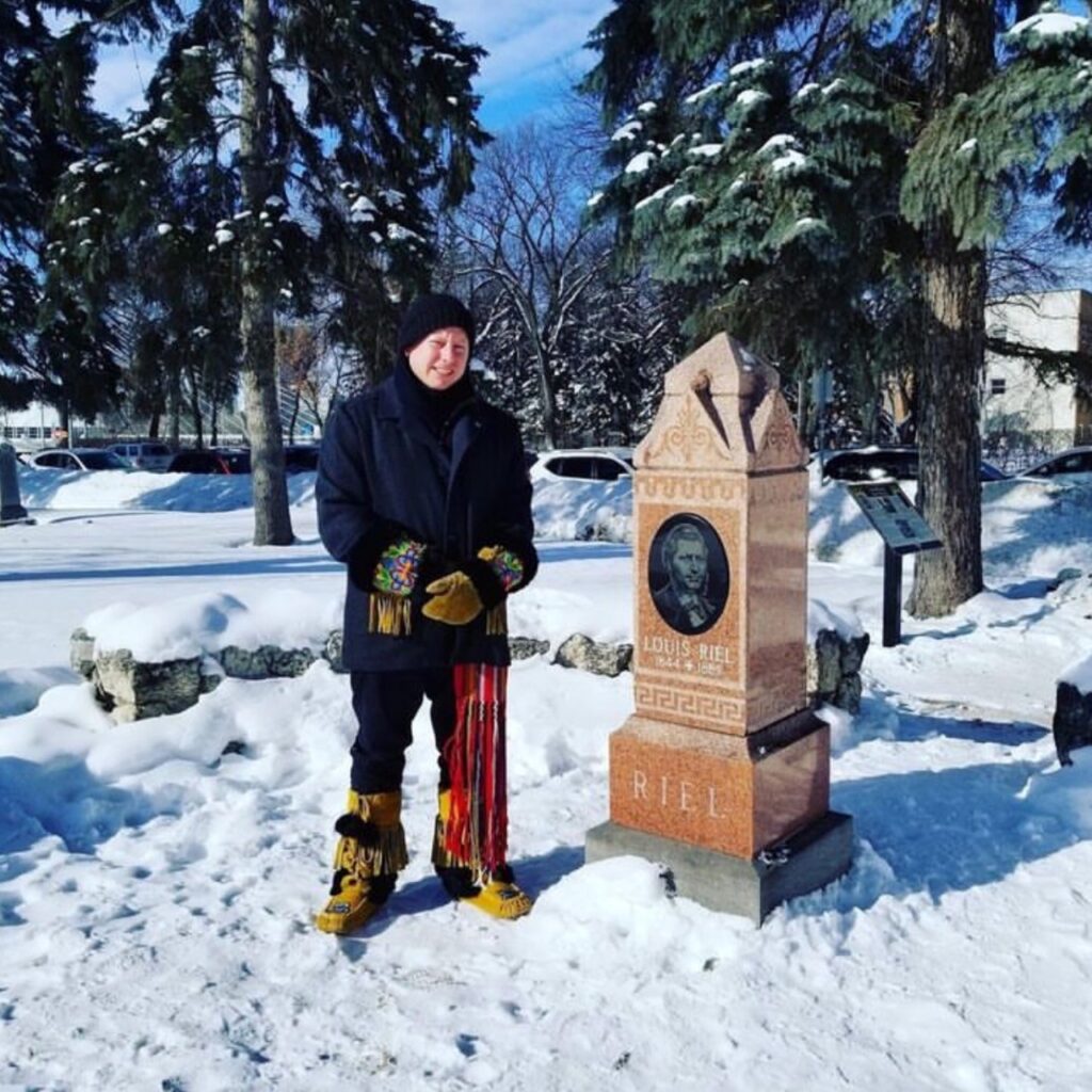 Shaun standing by Louis Riel grave