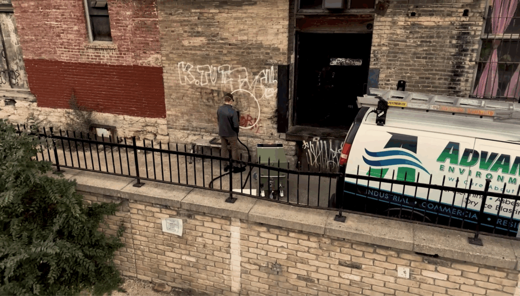 Drone footage of Advanced Environmental employee working on restoring a building facade.