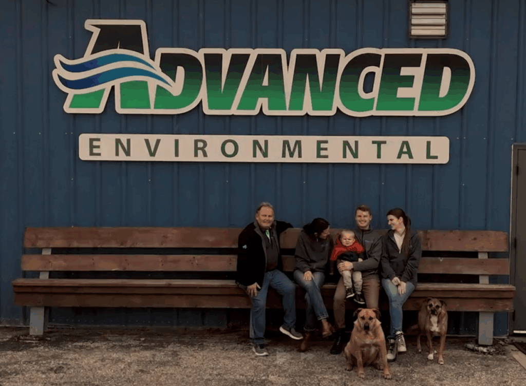 Family posed in front of Advanced Environmental office building exterior.